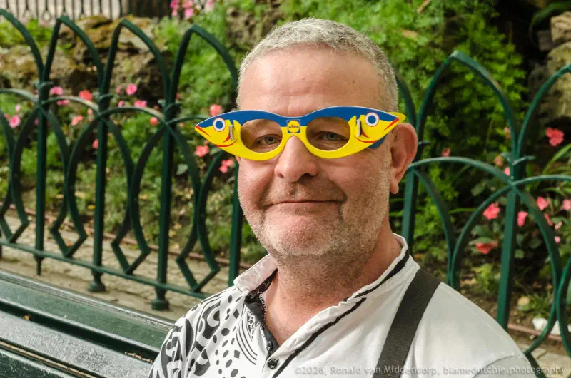 Man with cardboard spectacles in the shape of a sardine.