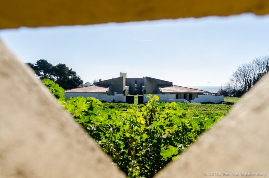 photo: building seen through hole in a wall